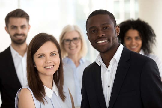 Head shot portrait of excited smiling diverse employees in office
