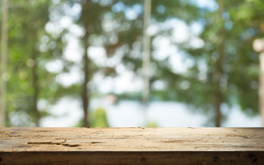 Empty of wood table top on blur of curtain with window view green from tree garden background.For montage product display or design key visual layout