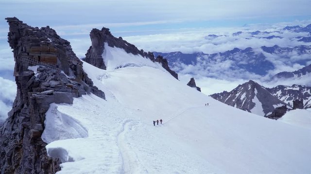 A group of climbers is on the glacier. They climb to the top of the Grand Paradiso in the Italian Alps. 4K