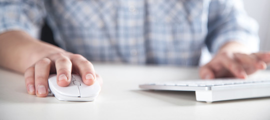 Girl using computer mouse and typing on keyboard.