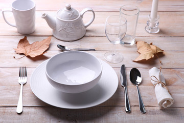 Fototapeta na wymiar white dishes, cutlery, glasses and candles