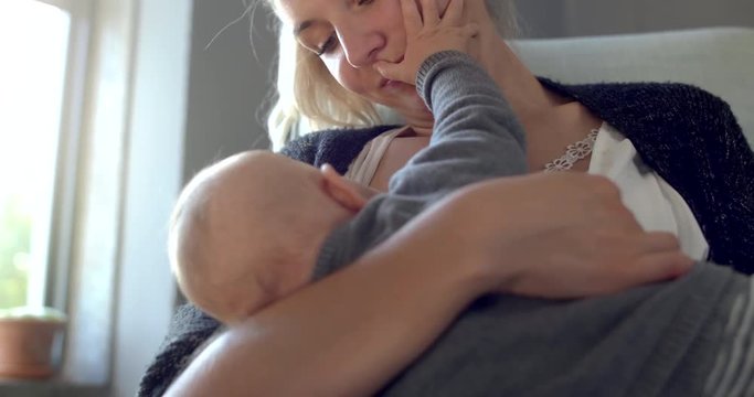 Young mother breastfeeding at home, bonding with baby child toddler