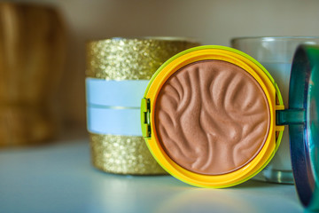 Decorative cosmetics, open compact make up bronxer case, beige bronzer. Professional make up concept.