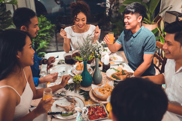 Asian group  friends eating dinner at home, they are happy to talk.