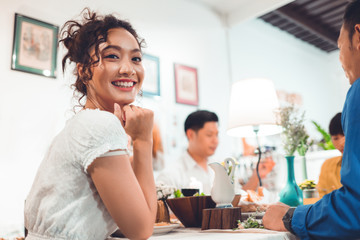 Asian people are eating dinner at home with friends they are happy to talk.