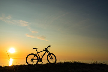 Fototapeta na wymiar beautiful sunset on the sea and the silhouette of a bicycle