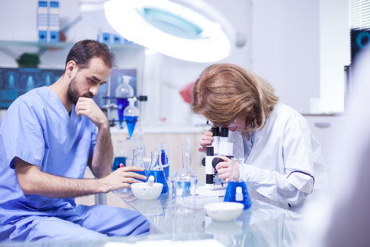 Middle Age Female Scientist Working With Microscope In Laboratory