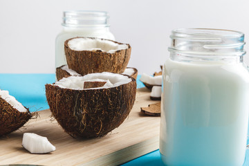Coconut pieces on wooden board on blue background