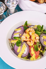 Mediterranean salad. grilled prawns, red onion rings, lemon peel, ginger root and vegetables dressed with olive oil