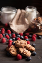 Close up of delicious pile of chocolate cookies with dark chocolate and fresh raspberries