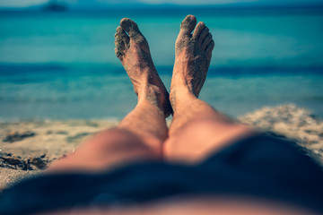 Man lying and enjoying on a sandy tropical beach.