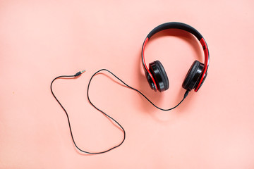 Headphones on pink background with free text space. Music concept.