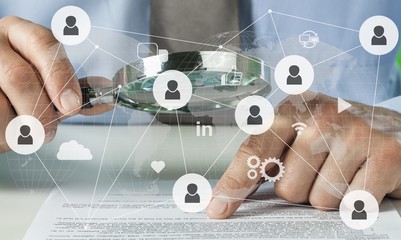 Business analytics and statistics. Businessman with report using a magnifying glass.