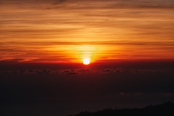 Sunrise / sunset over the clouds and horizon in golden colors.