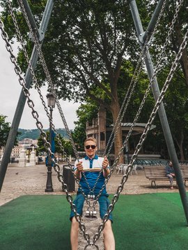 The blonde man swinging on a swing in a modern Bilabo