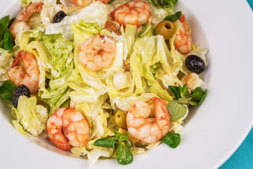 Mediterranean salad. Cabbage, tomatoes, shrimps, olives, olives, basil and rosemary, seasoned with olive oil