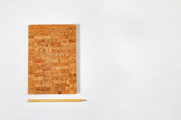 Flat lay with fashion copybook for writing and drawing, wooden pencil with graphite, on tabletop work space with copy space. Top view