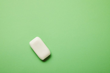 top view of white soap on green background with copy space