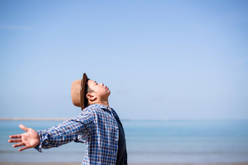 Side view of Happy excited man winner traveler or hipster raising arms up to blue sky feeling free motivatedover the beach enjoying beautiful view travel on vacation, freedom concept