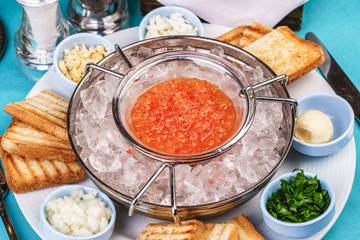 Mediterranean red caviar appetizer on ice, toast, butter, and a set of sauces