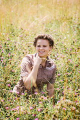 cheerful girl sitting in a clover