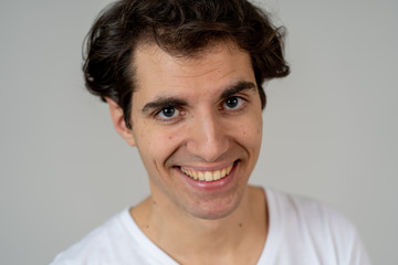 Fototapeta premium Portrait of young attractive cheerful man with smiling happy face. Human expressions and emotions