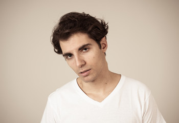 Obraz premium Natural portrait of young attractive man in his 20s looking and posing with neutral face expression