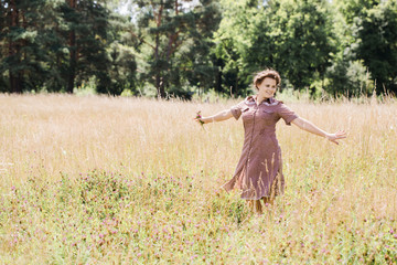 Naklejka na ściany i meble Young beautiful girl dancing in the field