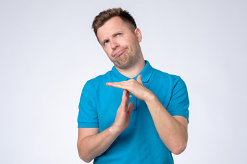 Man making time out gesture over grey background