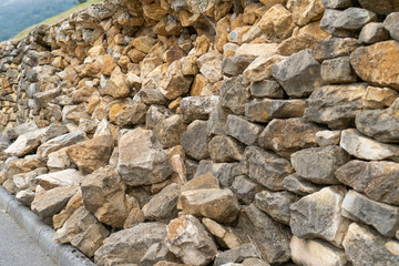 Destroyed retaining stone wall of natural stone after heavy rains
