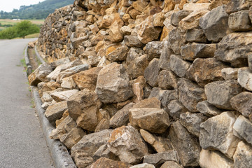 Destroyed retaining stone wall of natural stone after heavy rains