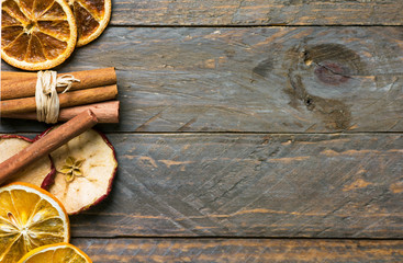 Homemade dried fruits slices of orange apple cinnamon sticks on on old plank wood background. New year Christmas decoration elements vintage style card poster. Ingredients for mulled wine tea