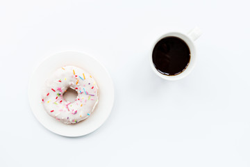 donut and black coffee with copy space. Cup of black coffee with donut on a plate on white table, top view, flat lay. Delicious breakfast.