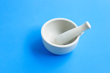 Mortar and pestle on blue background.