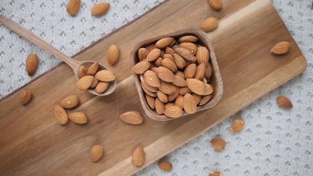 Top View Of Almonds On Wooden Board. Almond Nuts In Wooden Bowl.