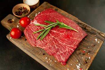 raw beef steak with herbs and spices on a stone background 