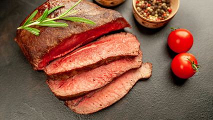 Fresh beef steak, herbs and spices on a stone background