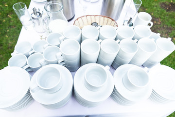 Lot of white porcelain coffee cups in the table in outdoors summer party