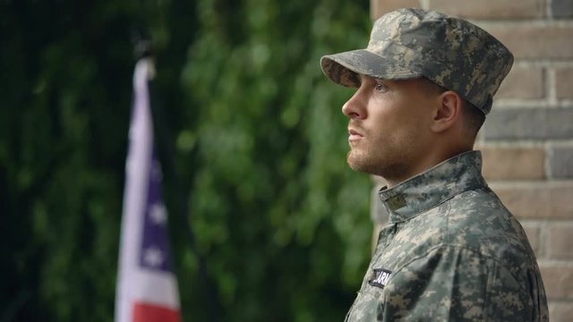 Pensive american military man looking at rain, suffering depression and ptsd