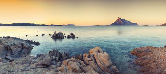 Fantastic azure water with rocks near beach Porto Taverna at sunset