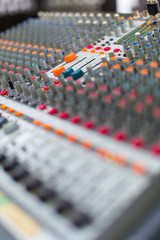 Analog sound mixer with selected focus. Professional audio mixing console radio and television broadcasting. Vertical shot.