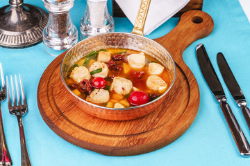 Italian fish soup with tomatoes, dough, dumplings, potatoes and greens. Mediterranean cuisine, European dish