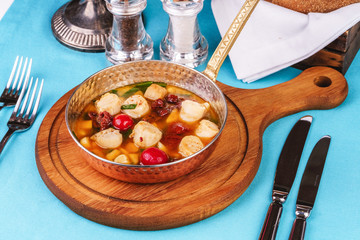 Italian fish soup with tomatoes, dough, dumplings, potatoes and greens. Mediterranean cuisine, European dish