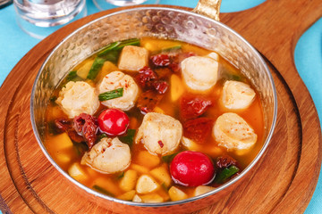 Italian fish soup with tomatoes, dough, dumplings, potatoes and greens. Mediterranean cuisine, European dish