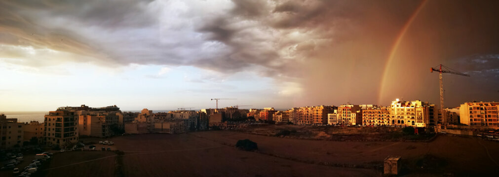 Rainbow and storm clouds over town, Bugibba, Malta