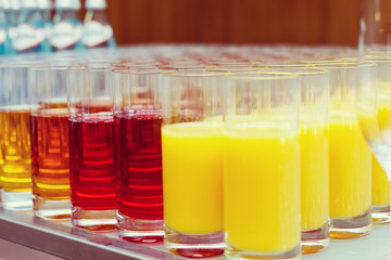 food background. many glasses with natural juice with orange on buffet table