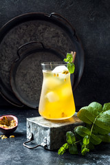 Passionfruit iced green tea or lemonade with lime and mint. Tropical refreshing cold drink for...