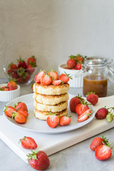 Cottage cheese pancakes syrniki with strawberries and honey. The concept of tasty healthy summer Breakfast. Copy space, side view.