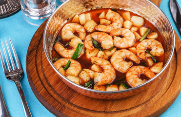 Seafood, Mediterranean cuisine, European dish. Warm salad of grilled fish pieces, shrimps and mussels in a frying pan, with grilled vegetables - with green onions, greens, mushrooms and vegetables.