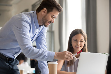 Mentor explaining task to smiling female employee